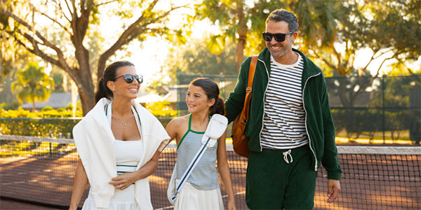 A family walking onto the Tennis Courts at Saddlebrook Resort